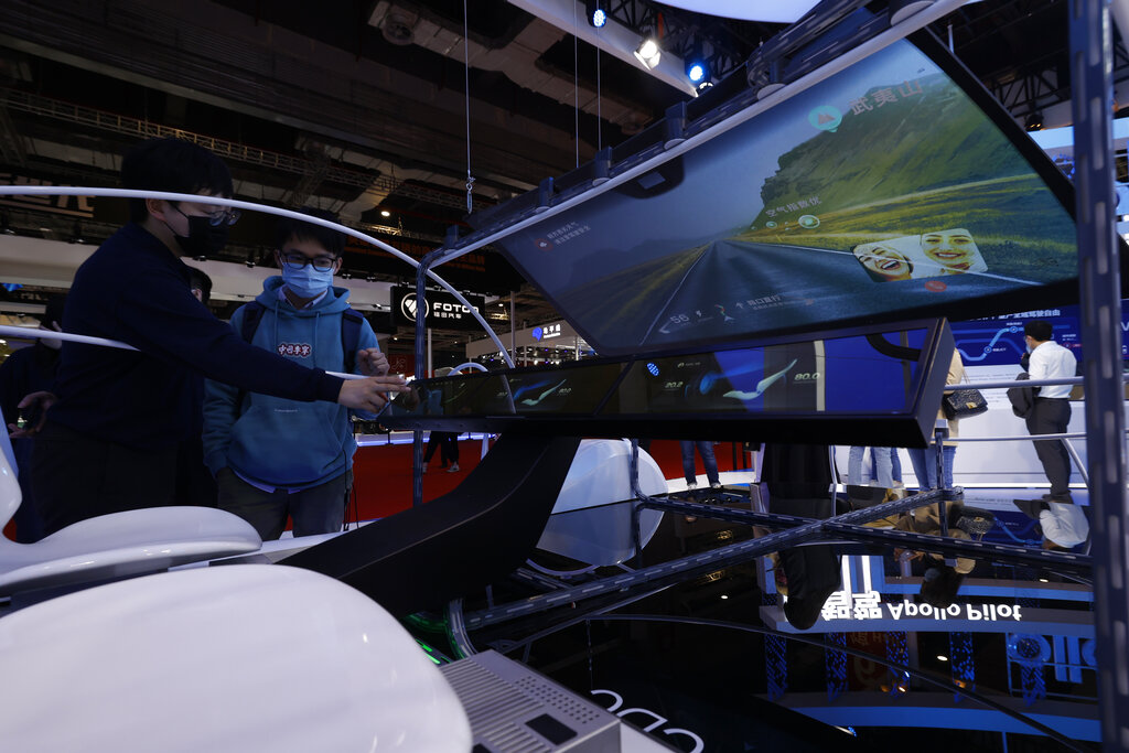Visitors look at the intelligent car product from Baidu's Apollo program during the Shanghai Auto Show in Shanghai on Monday, April 19, 2021. Automakers are looking to China, their biggest market by sales volume and the first major economy to rebound from the pandemic, to revive sales and reverse multibillion-dollar losses. (AP Photo/Ng Han Guan)