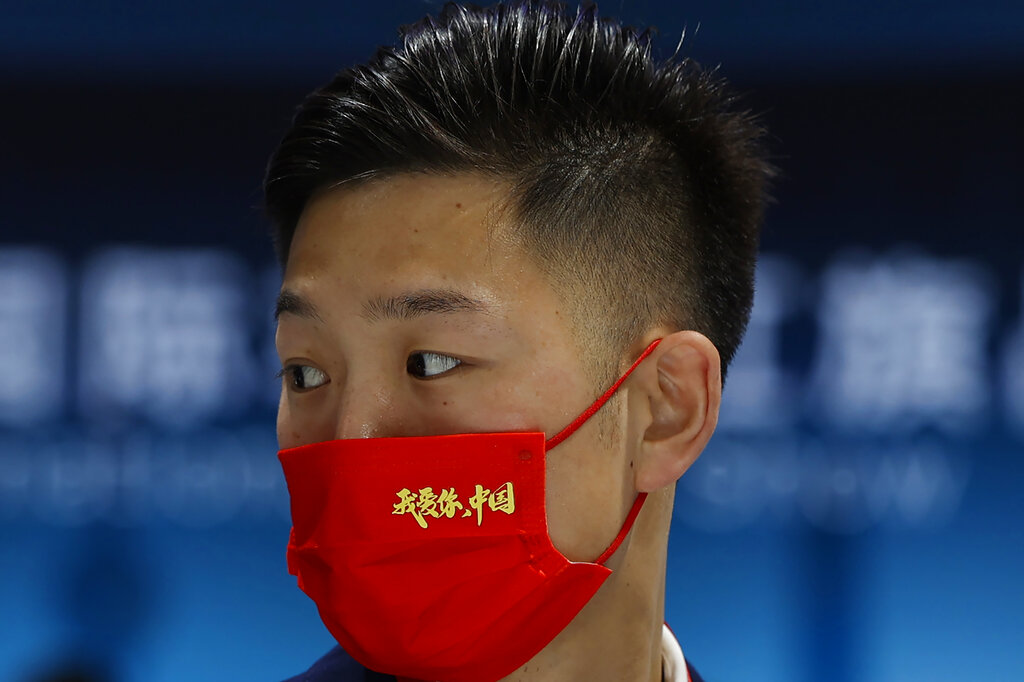 A promoter for the Chinese luxury auto brand Hongqi wears a mask that reads 