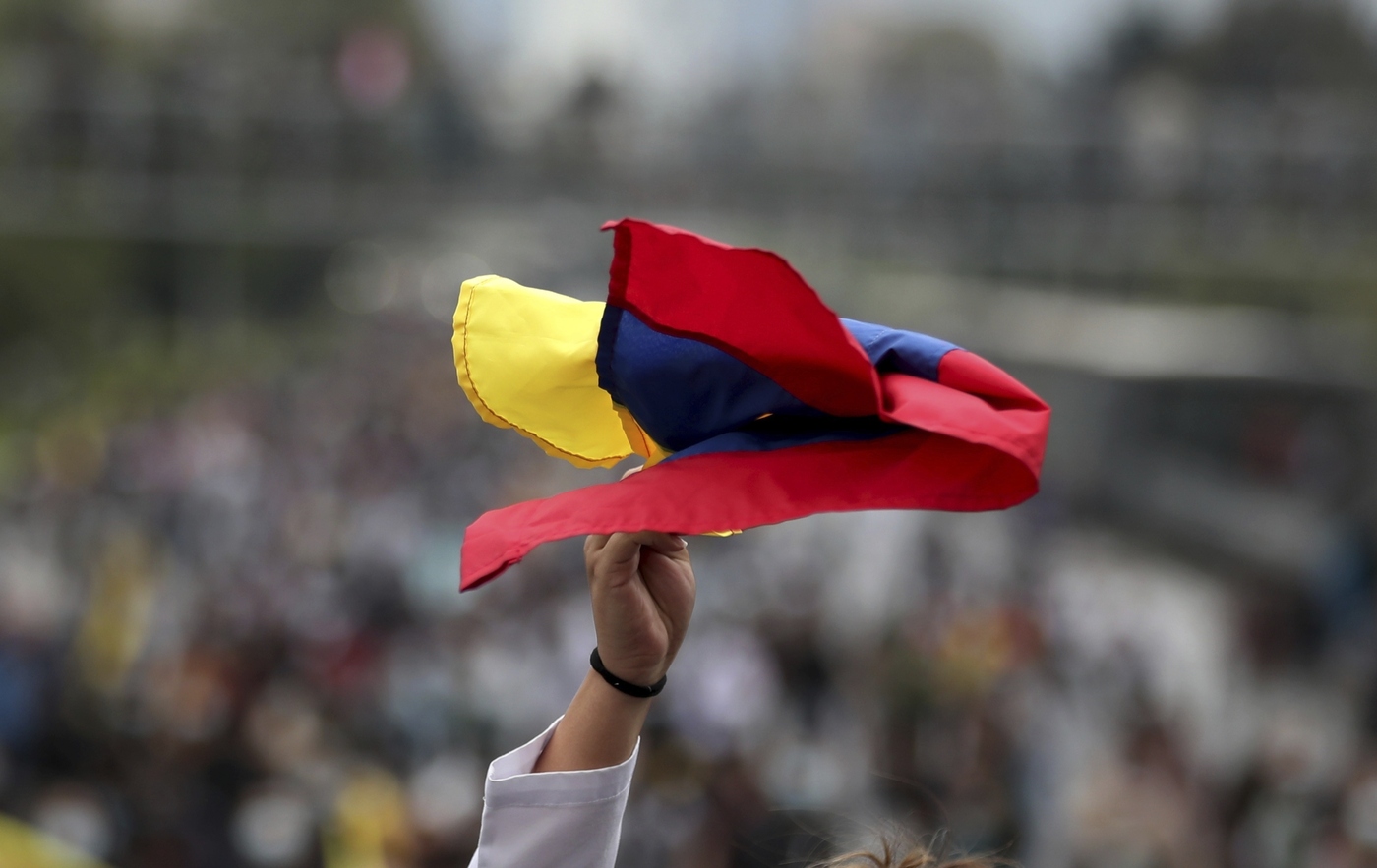 An university student holds a Colombian flag during a national strike against tax reform in Bogota, Colombia, Monday, May 3, 2021. Colombia's President Ivan Duque withdrew the government-proposed tax reform on Sunday. (AP Photo/Fernando Vergara)