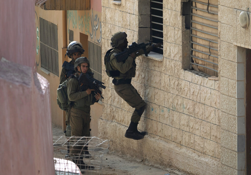 Israeli soldiers search for a suspected Palestinian gunmen in the village of Aqraba, near the West Bank town of Nablus, Tuesday, May 4, 2021. On Sunday gunmen in a passing car opened fire at Israelis standing at a major intersection in the Israeli-occupied West Bank, injuring three of them, according to rescue officials and the military. (AP Photo/Majdi Mohammed)