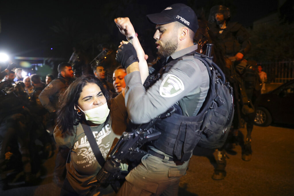 A Palestinian woman scuffles with Israeli border police officer during a protest against the planned evictions of Palestinian families in the Sheikh Jarrah neighborhood of east Jerusalem, Tuesday, May 4, 2021. (AP Photo/Mahmoud Illean)