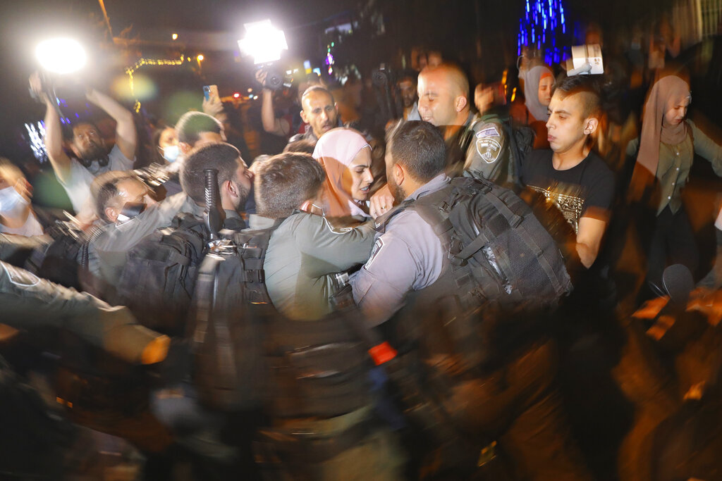 Palestinians scuffle with Israeli police officers during a protest against the planned evictions of Palestinian families in the Sheikh Jarrah neighborhood of east Jerusalem, Tuesday, May 4, 2021. (AP Photo/Mahmoud Illean)