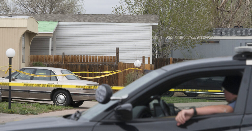 A Colorado Springs Police Department officer is stationed at the end of the street where multiple people were shot and killed early Sunday, May 9, 2021, in Colorado Springs, Colo.  The suspected shooter was the boyfriend of a female victim at the party attended by friends, family and children. He walked inside and opened fire before shooting himself, police said. Children at the attack weren’t hurt and were placed with relatives. (Jerilee Bennett/The Gazette via AP)
