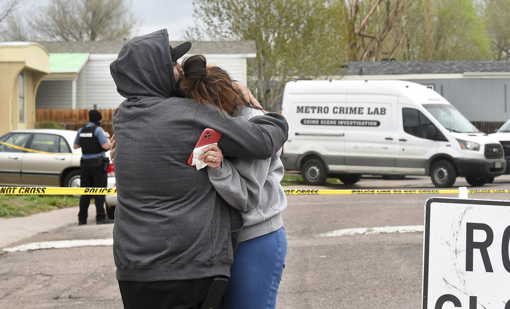 Freddy Marquez kisses the head of his wife, Nubia Marquez, near the scene where her mother and other family members were killed in a mass shooting early Sunday, May 9, 2021, in Colorado Springs, Colo.  The suspected shooter was the boyfriend of a female victim at the party attended by friends, family and children. He walked inside and opened fire before shooting himself, police said. Children at the attack weren’t hurt and were placed with relatives. (Jerilee Bennett/The Gazette via AP)