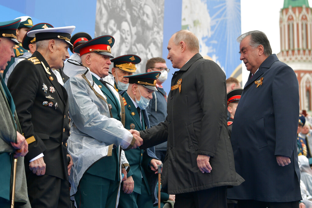 Russian President Vladimir Putin, second from right, and Tajikistan's President Emomali Rakhmon, right, shake hands with WWII veterans before the Victory Day military parade in Moscow, Russia, Sunday, May 9, 2021, marking the 76th anniversary of the end of World War II in Europe. (Alexei Druzhinin, Sputnik, Kremlin Pool Photo via AP)