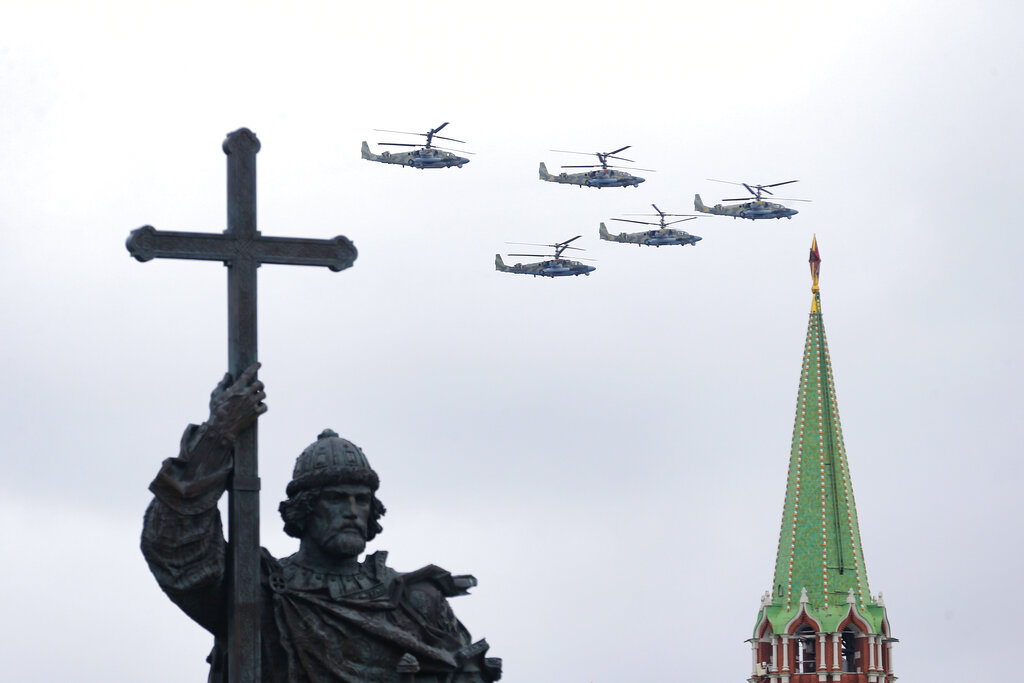 Russian military helicopters fly over the Kremlin with the statue of Vladimir the Great in the foreground during the Victory Day military parade in Moscow, Russia, Sunday, May 9, 2021, marking the 76th anniversary of the end of World War II in Europe. Russian President Vladimir Putin marked the anniversary of the end of World War II in Europe with a speech warning that Nazi beliefs remain strong. (AP Photo/Alexander Zemlianichenko Jr.)