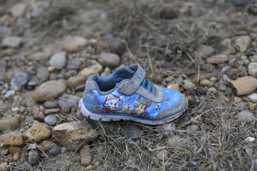 A child's shoe lies on the ground near the banks of the Rio Grande river in Roma, Texas Sunday, March 28, 2021. Roma, a town of 10,000 people in Texas' Rio Grande Valley, is the latest epicenter of illegal crossings. A soon as night falls, a steady stream of rafts carrying migrants cross the river to U.S. soil. (AP Photo/Dario Lopez-Mills)
