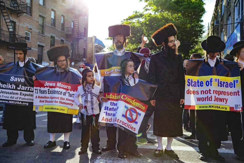 Orthodox Jewish men hold anti-Israel signage as thousands of activists supporting Palestine converge Saturday, May 15, 2021, in New York. The rally supports Palestine in the ongoing conflict between Israel and Palestine on the day Israeli airstrikes leveled several buildings in the Gaza strip. (AP Photo/Kevin Hagen)