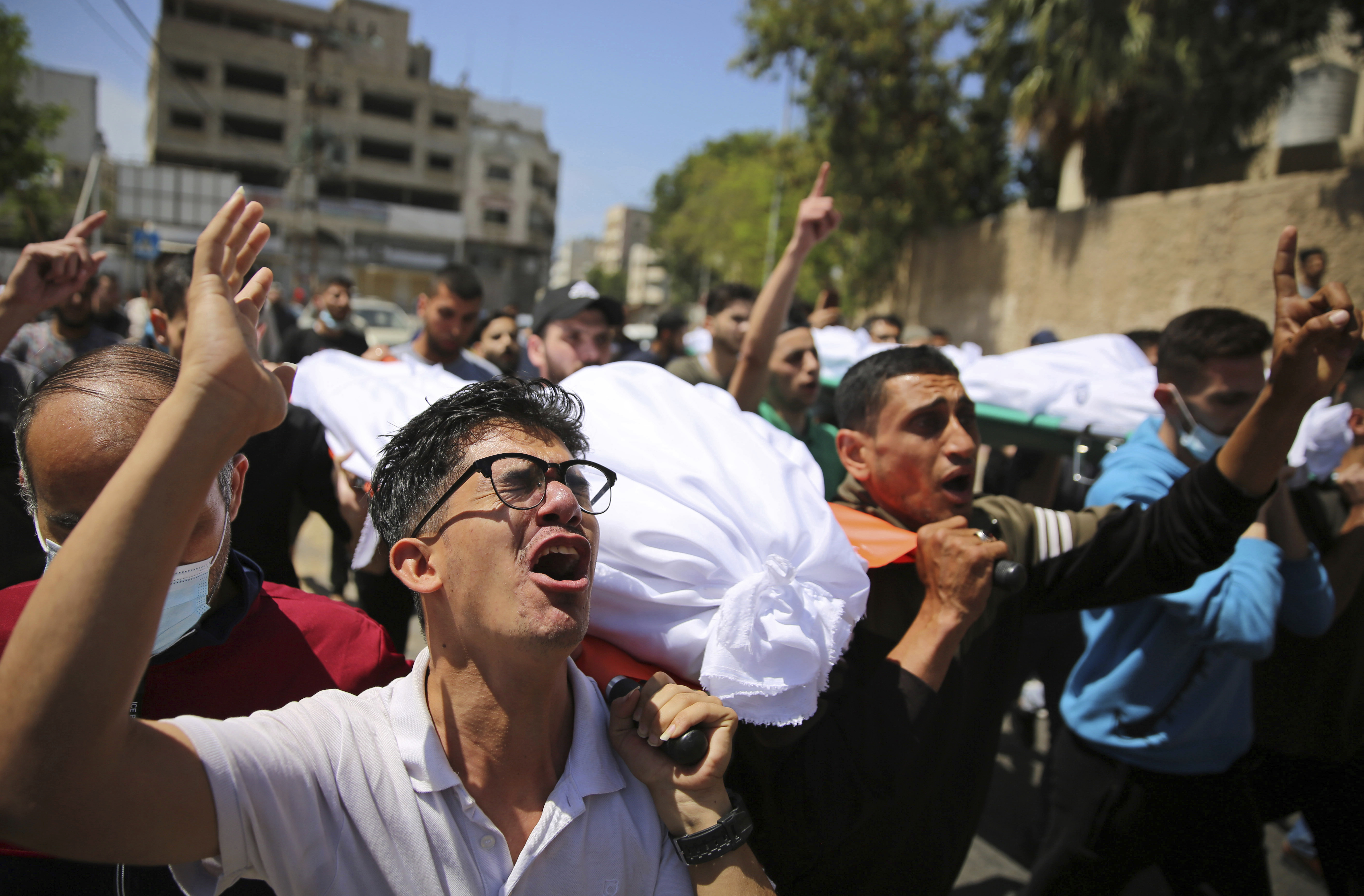Mourners carry the the bodies of Palestinians who were killed in overnight Israeli airstrikes that hit their homes, during their funeral in Gaza City, Sunday, May 16, 2021. (AP Photo/Abdel Kareem Hana)