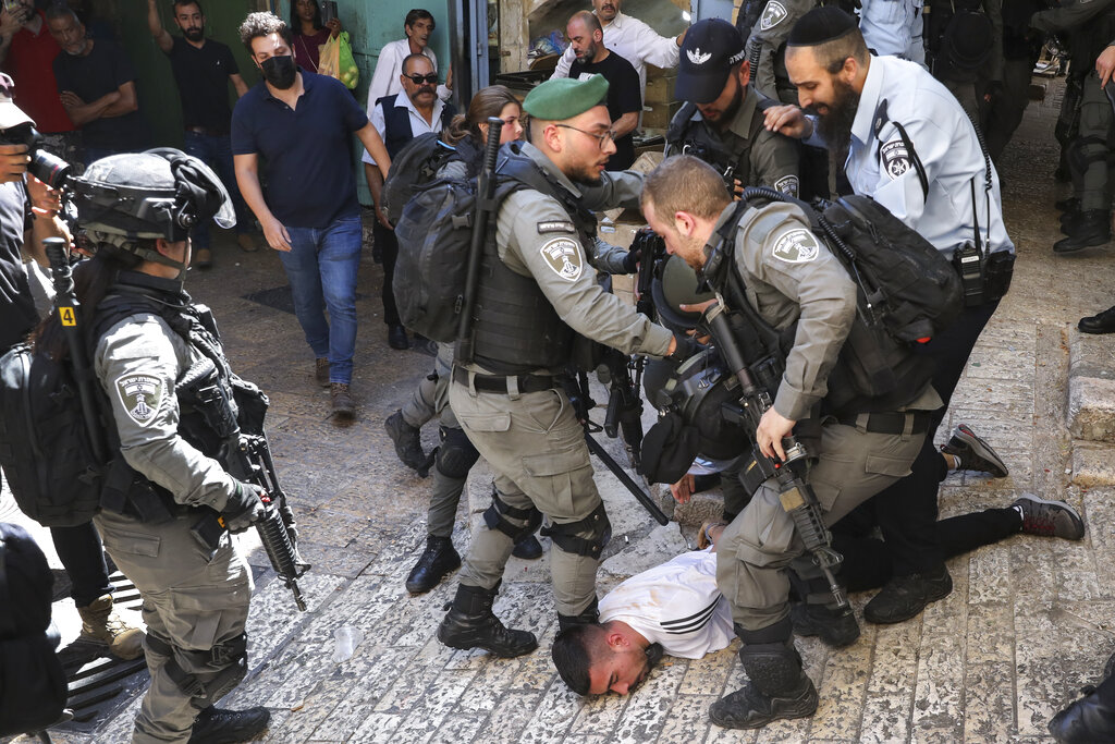 Israeli police officers detain a Palestinian youth during a protest against Israel's air strikes on the Gaza Strip and the violent confrontations between Israeli security forces and Palestinians, in Jerusalem's Old City, Tuesday, May 18, 2021. (AP Photo/Mahmoud Illean)