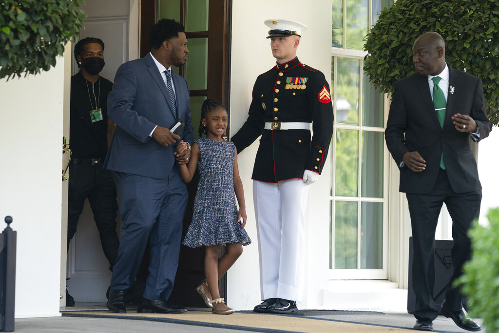 A Marine holds the door as Gianna Floyd, the daughter of George Floyd, and family members walk out of the White House, Tuesday, May 25, 2021, in Washington. (AP Photo/Evan Vucci)