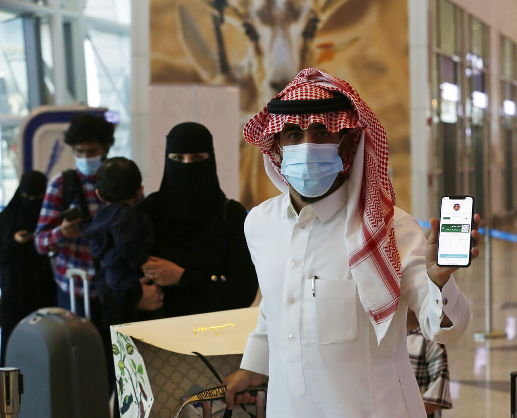 Saudi passenger, Sultan Saeed Al-Shahrani, shows his vaccination certificate on his phone, at a checkpoint in King Abdulaziz International Airport in Jiddah, Saudi Arabia, Monday, May 17, 2021. Vaccinated Saudis will be allowed to leave the kingdom for the first time in more than a year as the country eases a ban on international travel that had been in place to try and contain the spread of the coronavirus and its new variants. (AP Photo/Amr Nabil)