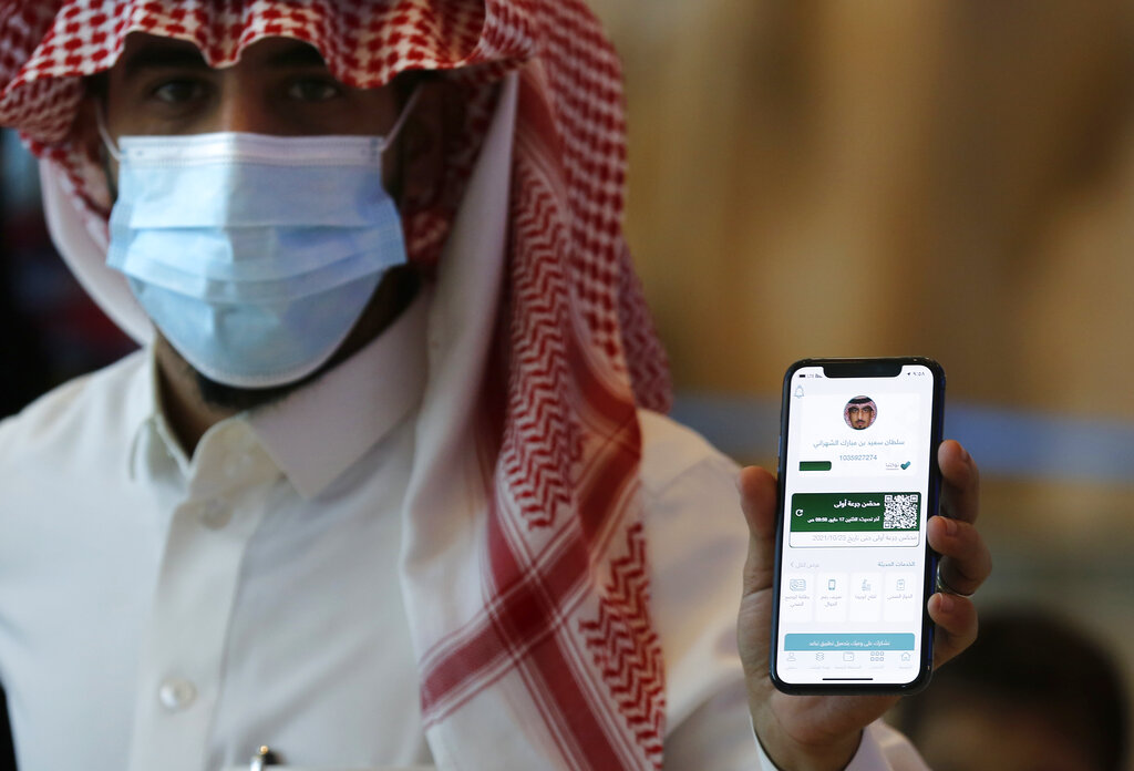 Saudi passenger, Sultan Saeed Al-Shahrani, shows his vaccination certificate on his mobile phone, at a checkpoint at King Abdulaziz International Airport in Jiddah, Saudi Arabia, Monday, May 17, 2021. Vaccinated Saudis will be allowed to leave the kingdom for the first time in more than a year as the country eases a ban on international travel that had been in place to try and contain the spread of the coronavirus and its new variants. (AP Photo/Amr Nabil)