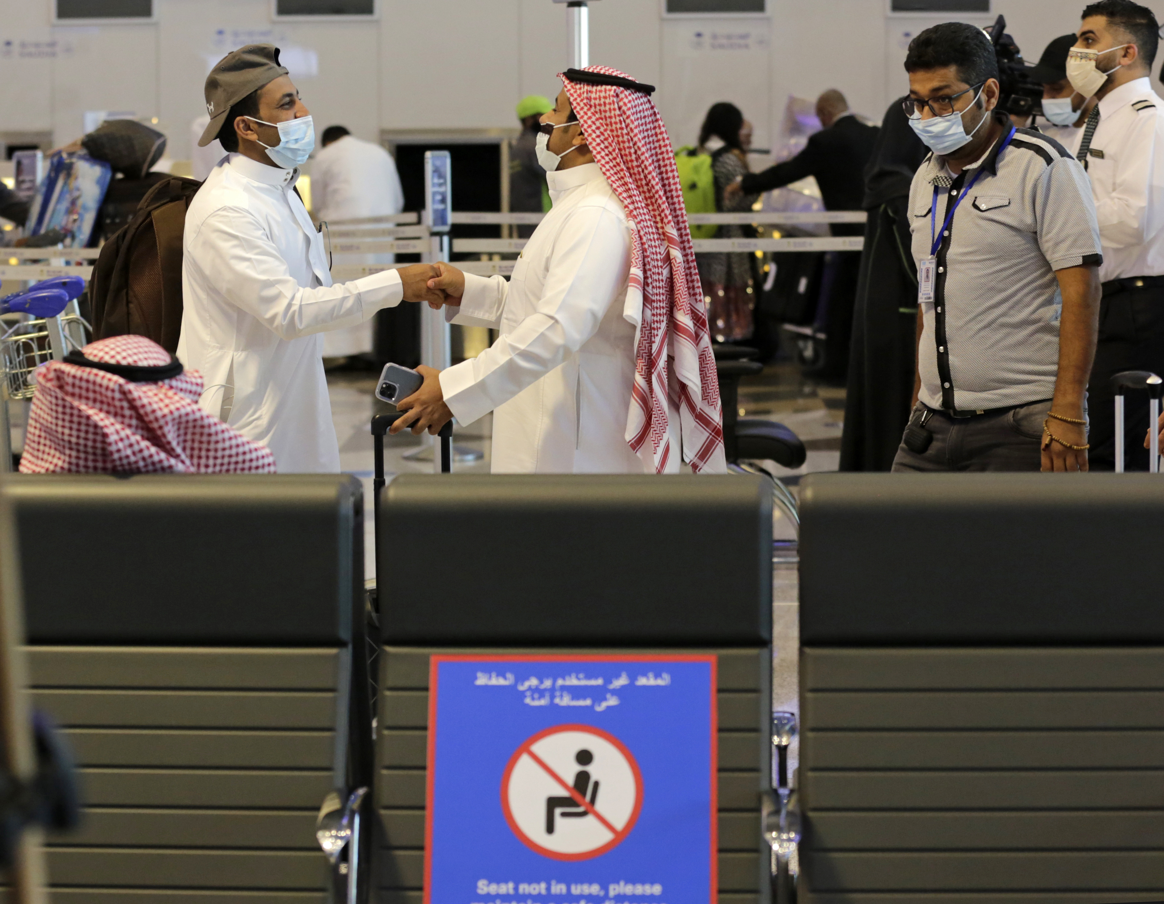 Saudi passengers greet each other as they prepare to fly out of King Abdulaziz International Airport, in Jiddah, Saudi Arabia, Monday, May 17, 2021. Vaccinated Saudis are allowed to leave the kingdom for the first time in more than a year as the country eases a ban on international travel that had been in place to try and contain the spread of the coronavirus and its new variants. (AP Photo/Amr Nabil)