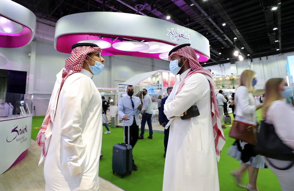 Saudi exhibitors talk at their stand at the Arabian Travel Market exhibition, in Dubai, United Arab Emirates, Sunday, May 16, 2021. Vaccinated Saudis are allowed to leave the kingdom for the first time in more than a year on Monday as the country eases a ban on international travel aimed at containing the spread of the coronavirus and its new variants. (AP Photo/Kamran Jebreili)