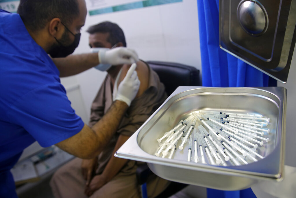 A Saudi physician gives a Pfizer coronavirus vaccine to a man at a vaccination center in the old Jiddah airport, Saudi Arabia, Tuesday, May 18, 2021. (AP Photo/Amr Nabil)