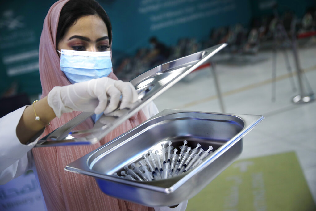 A Saudi health worker carries a tray of Pfizer coronavirus vaccines, at a vaccination center in the old Jiddah airport, Saudi Arabia, Tuesday, May 18, 2021. (AP Photo/Amr Nabil)