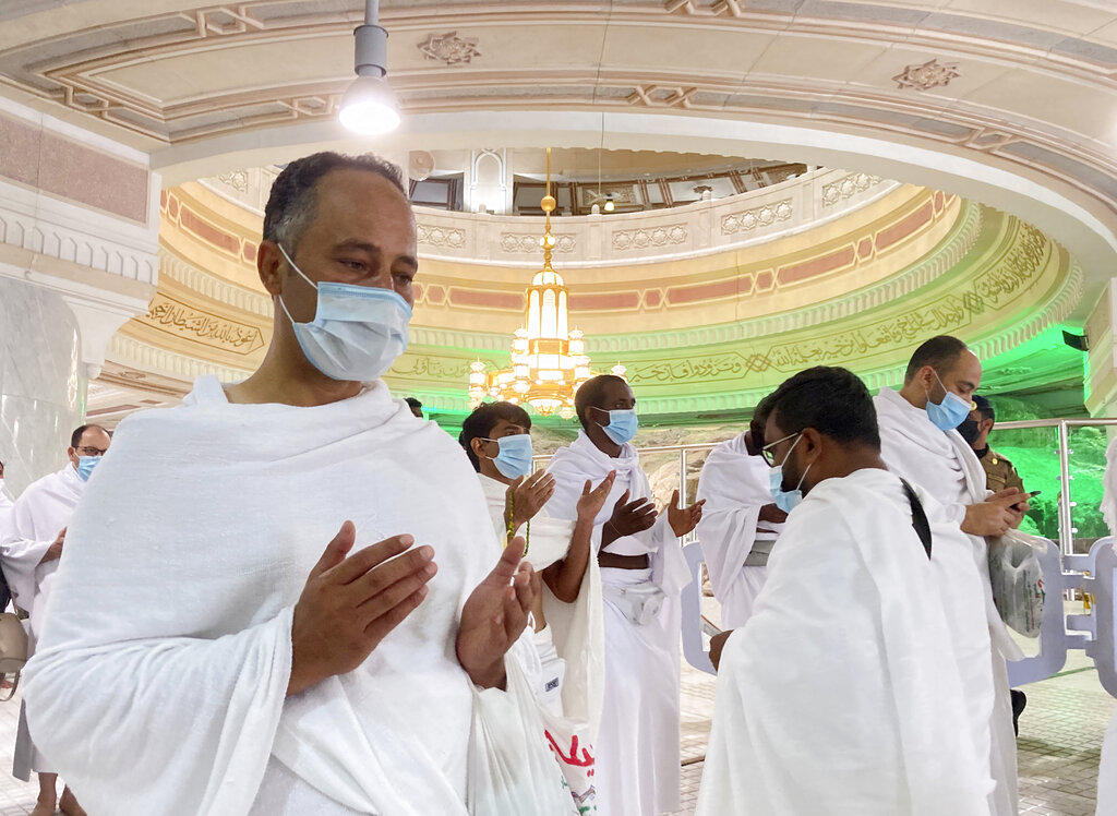 Muslim pilgrims wear face masks to help stop the spread of the coronavirus as they pray in front of the holy Al Safaa mountain at the Grand Mosque in the Muslim holy city of Mecca, Saudi Arabia, Sunday, May 30, 2021. (AP Photo/Amr Nabil)