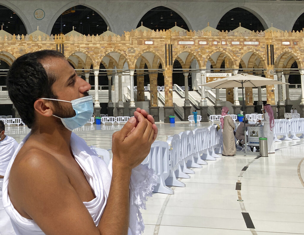 A Muslim pilgrim wears a face mask to help stop the spread of the coronavirus as he prays at the Grand Mosque in the Muslim holy city of Mecca, Saudi Arabia, Sunday, May 30, 2021. (AP Photo/Amr Nabil)