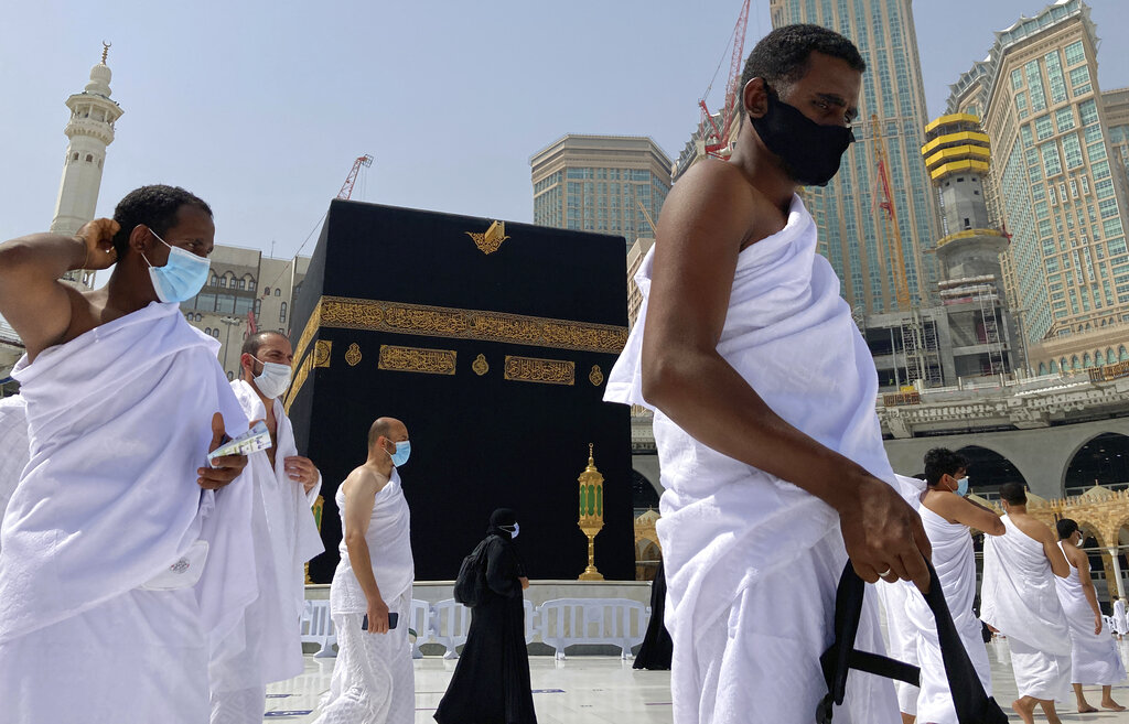 Muslim pilgrims circumambulate the Kaaba, the cubic building at the Grand Mosque, as they wear masks and keep social distancing during the minor pilgrimage, known as Umrah, in the Muslim holy city of Mecca, Saudi Arabia, Sunday, May 30, 2021.(AP Photo/Amr Nabil)