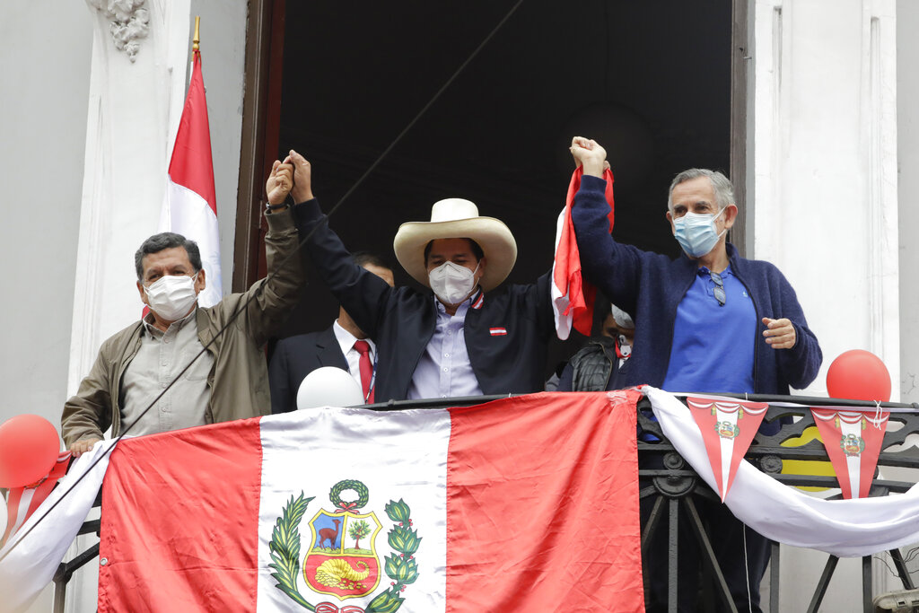 Presidential candidate Pedro Castillo, center, celebrates partial election results at his campaign headquarters in Lima, Peru, Monday, June 7, 2021, the day after the runoff election. (AP Photo/Guadalupe Pardo)