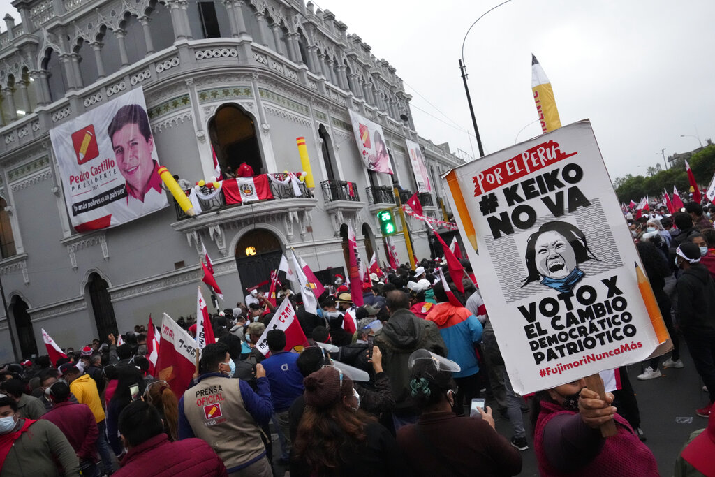 Supporters of presidential candidate Pedro Castillo hold a sign depicting Keiko Fujimori as they listen to partial election results that show Castillo leading over her in Lima, Peru, Monday, June 7, 2021, the day after a runoff election. (AP Photo/Martin Mejia)