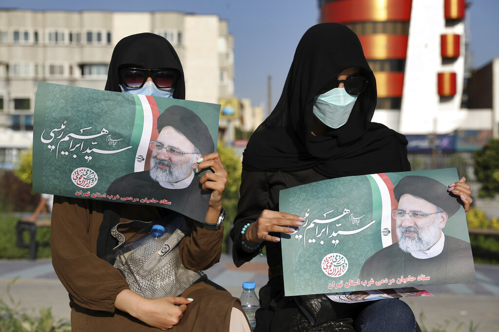 Supporters of presidential candidate Ebrahim Raisi hold signs during a rally in Tehran, Iran, Monday, June 14, 2021. Iran's clerical vetting committee has allowed just seven candidates for the Friday, June 18, ballot, nixing prominent reformists and key allies of President Hassan Rouhani. The presumed front-runner has become Ebrahim Raisi, the country's hard-line judiciary chief who is closely aligned with Supreme Leader Ayatollah Ali Khamenei. (AP Photo/Ebrahim Noroozi)
