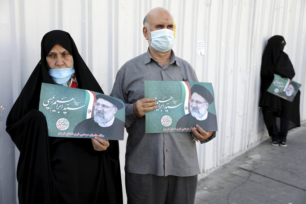 Supporters of presidential candidate Ebrahim Raisi hold his signs during a rally in Tehran, Iran, Monday, June 14, 2021. Iran's clerical vetting committee has allowed just seven candidates for the Friday, June 18, ballot, nixing prominent reformists and key allies of President Hassan Rouhani. The presumed front-runner has become Ebrahim Raisi, the country's hard-line judiciary chief who is closely aligned with Supreme Leader Ayatollah Ali Khamenei. (AP Photo/Ebrahim Noroozi)