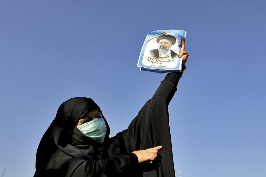 A supporter of presidential candidate of Ebrahim Raisi holds up his sign during a rally in Tehran, Iran, Monday, June 14, 2021. Iran's clerical vetting committee has allowed just seven candidates for the Friday, June 18, ballot, nixing prominent reformists and key allies of President Hassan Rouhani. The presumed front-runner has become Ebrahim Raisi, the country's hard-line judiciary chief who is closely aligned with Supreme Leader Ayatollah Ali Khamenei. (AP Photo/Ebrahim Noroozi)