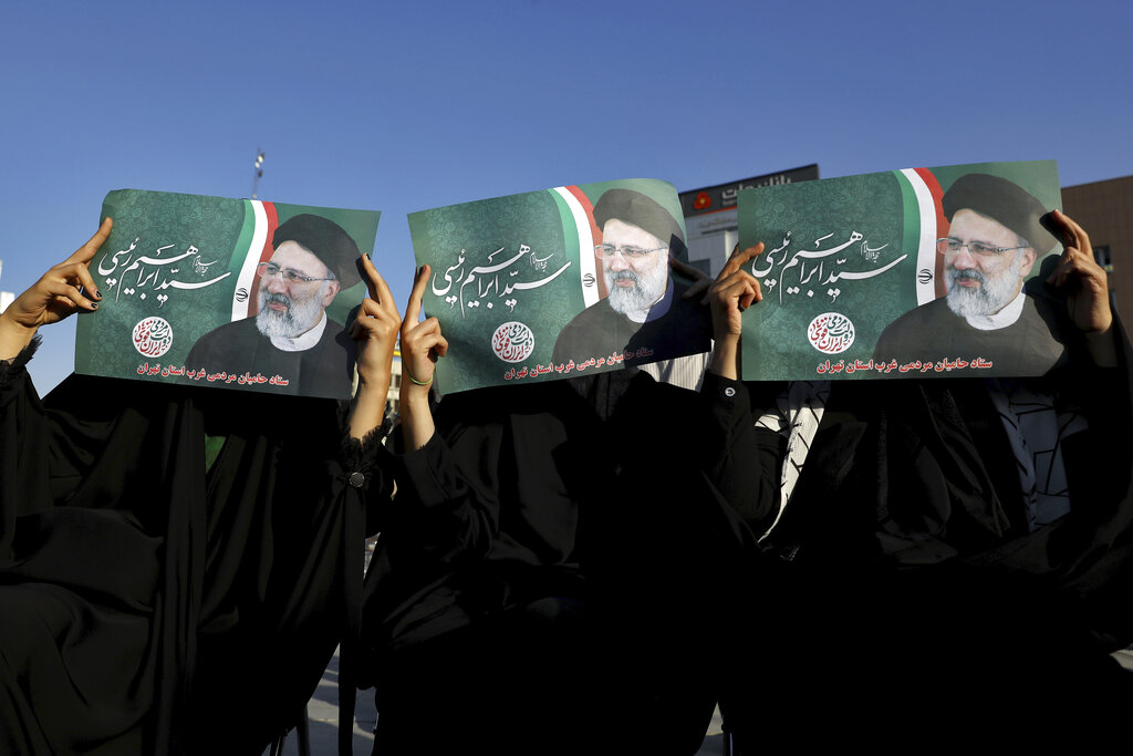 Supporters of presidential candidate Ebrahim Raisi hold up his signs during a rally in Tehran, Iran, Monday, June 14, 2021. Iran's clerical vetting committee has allowed just seven candidates for the Friday, June 18, ballot, nixing prominent reformists and key allies of President Hassan Rouhani. The presumed front-runner has become Ebrahim Raisi, the country's hard-line judiciary chief who is closely aligned with Supreme Leader Ayatollah Ali Khamenei. (AP Photo/Ebrahim Noroozi)