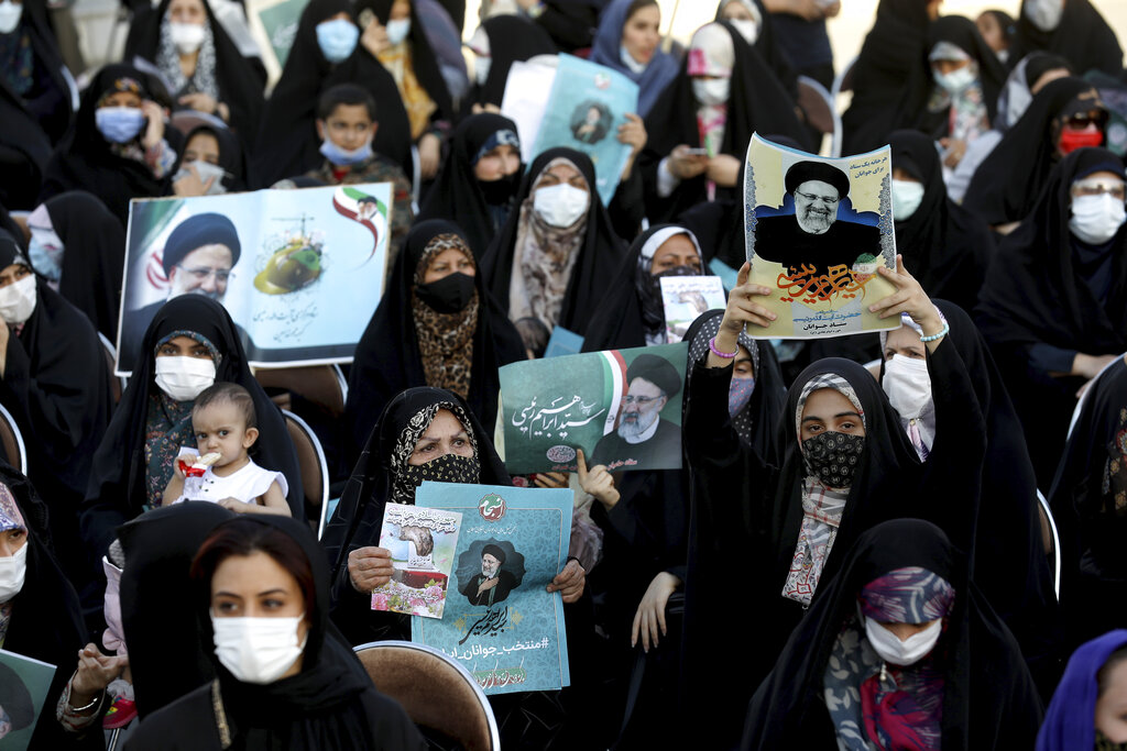 Supporters of presidential candidate Ebrahim Raisi, shown in the posters, attend a rally in Tehran, Iran, Monday, June 14, 2021. Iran's clerical vetting committee has allowed just seven candidates for the Friday, June 18, ballot, nixing prominent reformists and key allies of President Hassan Rouhani. The presumed front-runner has become Ebrahim Raisi, the country's hard-line judiciary chief who is closely aligned with Supreme Leader Ayatollah Ali Khamenei. (AP Photo/Ebrahim Noroozi)