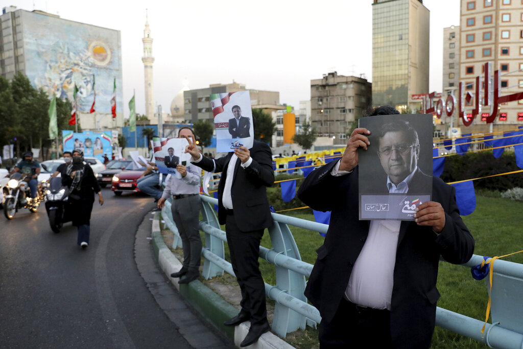 Supporters of presidential candidate Abdolnasser Hemmati hold up signs in a street rally in Tehran, Iran, Monday, June 14, 2021. Iran's clerical vetting committee has allowed just seven candidates for the Friday, June 18, ballot, nixing prominent reformists and key allies of President Hassan Rouhani. The presumed front-runner has become Ebrahim Raisi, the country's hard-line judiciary chief who is closely aligned with Supreme Leader Ayatollah Ali Khamenei. (AP Photo/Ebrahim Noroozi)