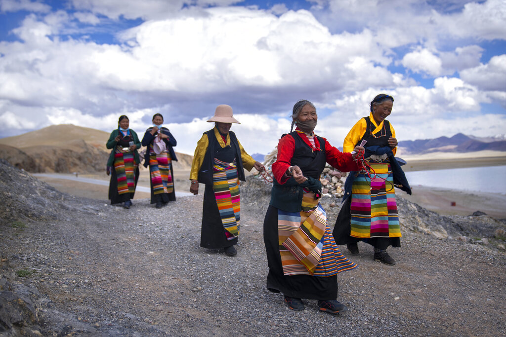 Tibetan women circumnavigate a Buddhist religious site in Namtso in western China's Tibet Autonomous Region, as seen during a government organized visit for foreign journalists, Wednesday, June 2, 2021. (AP Photo/Mark Schiefelbein)