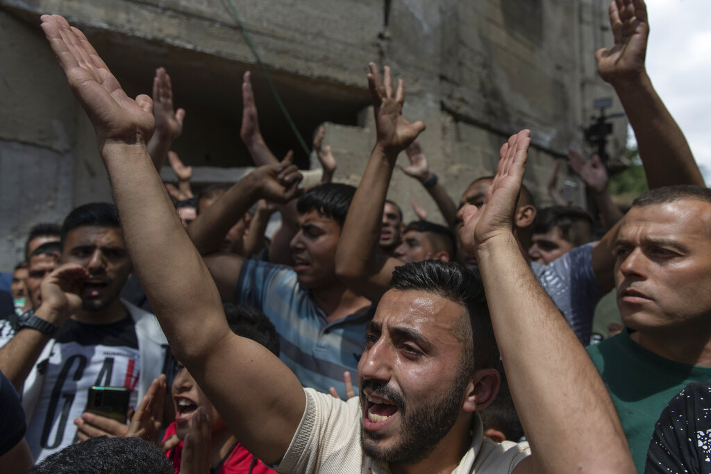 Palestinian mourners chant anti Israel slogans during the funeral of Ahmad Shamsa, 15, in the West Bank village of Beta, near Nablus, Thursday, June. 17, 2021. The Palestinian health ministry said Thursday that Shamsa, who was shot by Israeli troops in the West Bank a day earlier, died of his injuries. (AP Photo/Nasser Nasser)