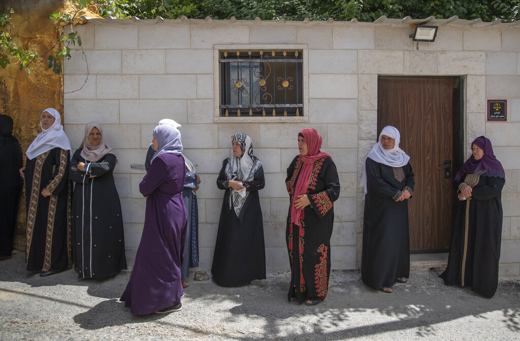 Palestinian women wait by the family house to take the last look at the body of Ahmad Shamsa, 15, during his funeral in the West Bank village of Beta, near Nablus, Thursday, June. 17, 2021. The Palestinian health ministry said Thursday that Shamsa who was shot by Israeli troops in the West Bank a day earlier died of his injuries. (AP Photo/Nasser Nasser)