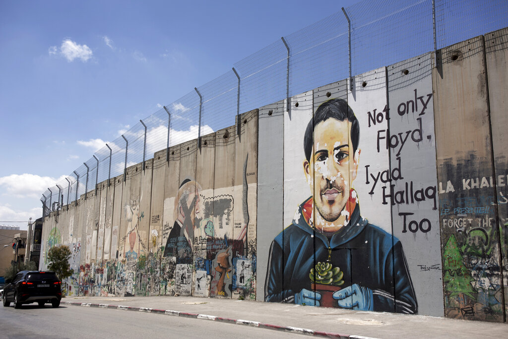 A mural depicting Eyad Hallaq, an autistic Palestinian man who was killed by Israeli police in Jerusalem's Old City last year, is seen on Israel's controversial separation barrier, in the West Bank town of Bethlehem, Friday, April 9, 2021. Israeli prosecutors on Thursday, June 17, 2021 charged a border police officer with reckless manslaughter in the deadly shooting. (AP Photo / Maya Alleruzzo)
