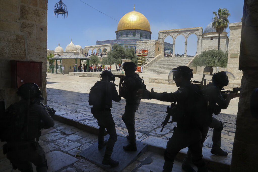 FILE - In this June 18, 2021, file photo, Israeli security forces take positions during clashes with Palestinians in front of the Dome of the Rock Mosque at the Al Aqsa Mosque compound in Jerusalem's Old City. Palestinians and Jewish settlers hurled stones, chairs and fireworks at each other overnight in a tense Jerusalem neighborhood where settler groups are trying to evict several Palestinian families, officials said Tuesday, June 22. (AP Photo/Mahmoud Illean, File)