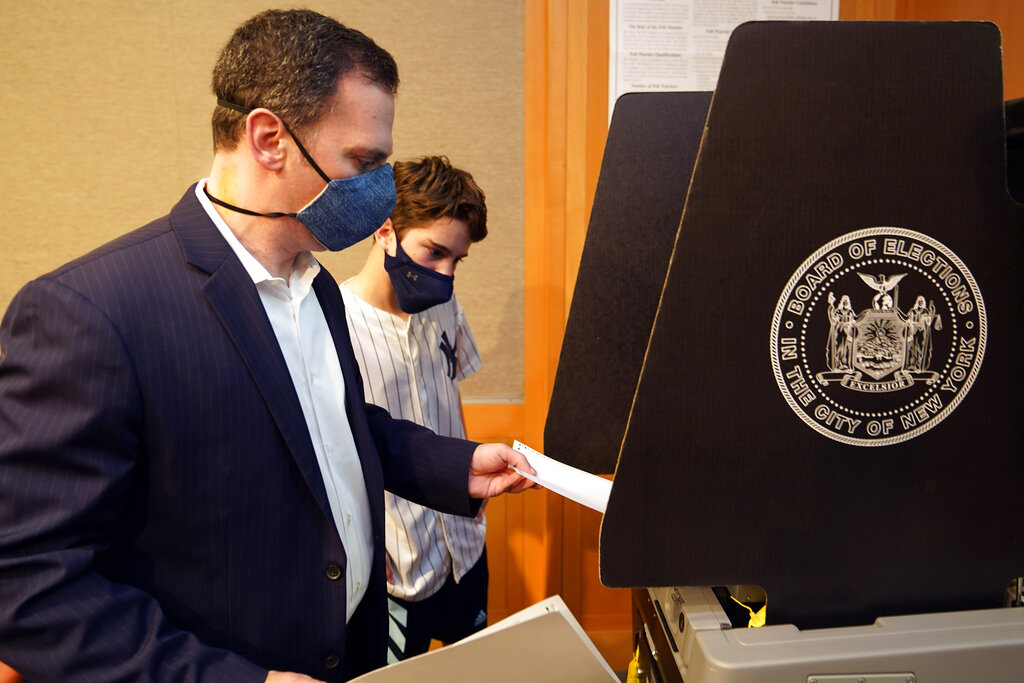 New York State Assembly member, and candidate for Manhattan district attorney, Dan Quart, with his son Sam, enters his ballot at an early voting site at the Metropolitan Museum of Art, in New York, Thursday, June 17, 2021. (AP Photo/Richard Drew)