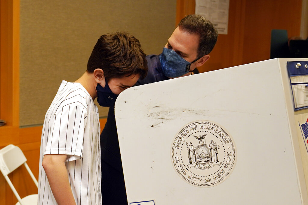 New York State Assembly member, and candidate for Manhattan district attorney, Dan Quart, with his son Sam, marks his ballot at an early voting site at the Metropolitan Museum of Art, in New York, Thursday, June 17, 2021. (AP Photo/Richard Drew)