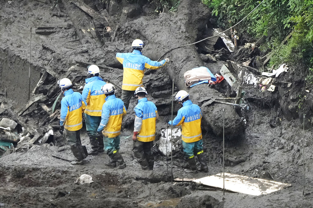 Police officers search through a mudslide area caused by heavy rains in Atami, Shizuoka Prefecture, west of Tokyo, Monday, July 5, 2021. Rescue workers are slogging through mud and debris looking for dozens unaccounted for after a giant landslide ripped through the Japanese seaside resort town. (AP Photo/Eugene Hoshiko)