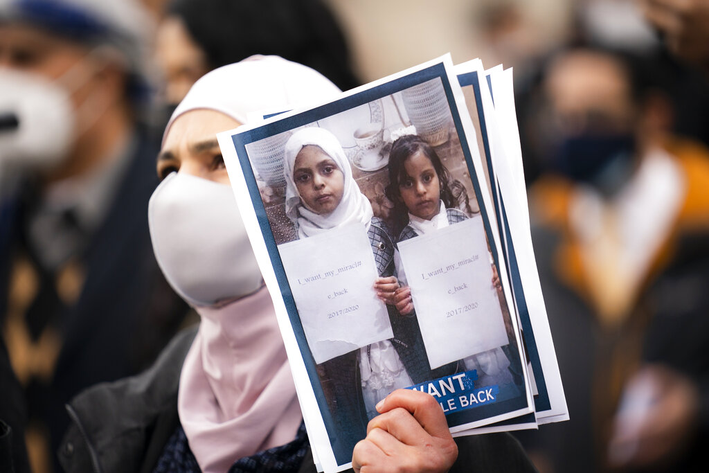 Demonstrators hold images of Yemeni civilians who were barred from immigrating to the United States during an 