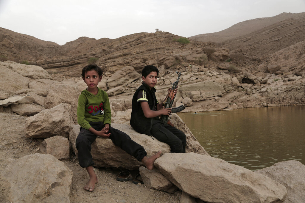 FILE - In this July 30, 2018, file photo, a 17-year-old boy holds his weapon at the dam in Marib, Yemen. The battle for the ancient desert city has become key to understanding wider tensions now inflaming the Middle East and the challenges facing any efforts by President Joe Biden’s administration to shift U.S. troops out of the region. (AP Photo/Nariman El-Mofty, File)