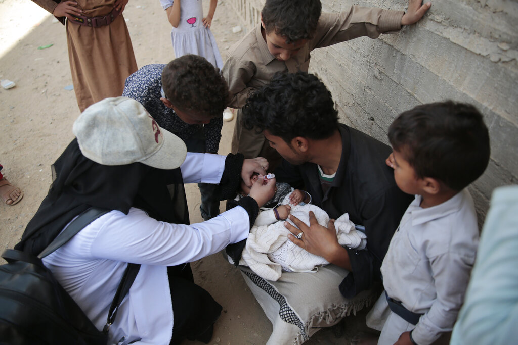 A Yemeni health worker gives the polio vaccination to a child during a house-to-house polio immunization campaign in Sanaa, Yemen, Sunday, May 30, 2021. (AP Photo/Hani Mohammed)