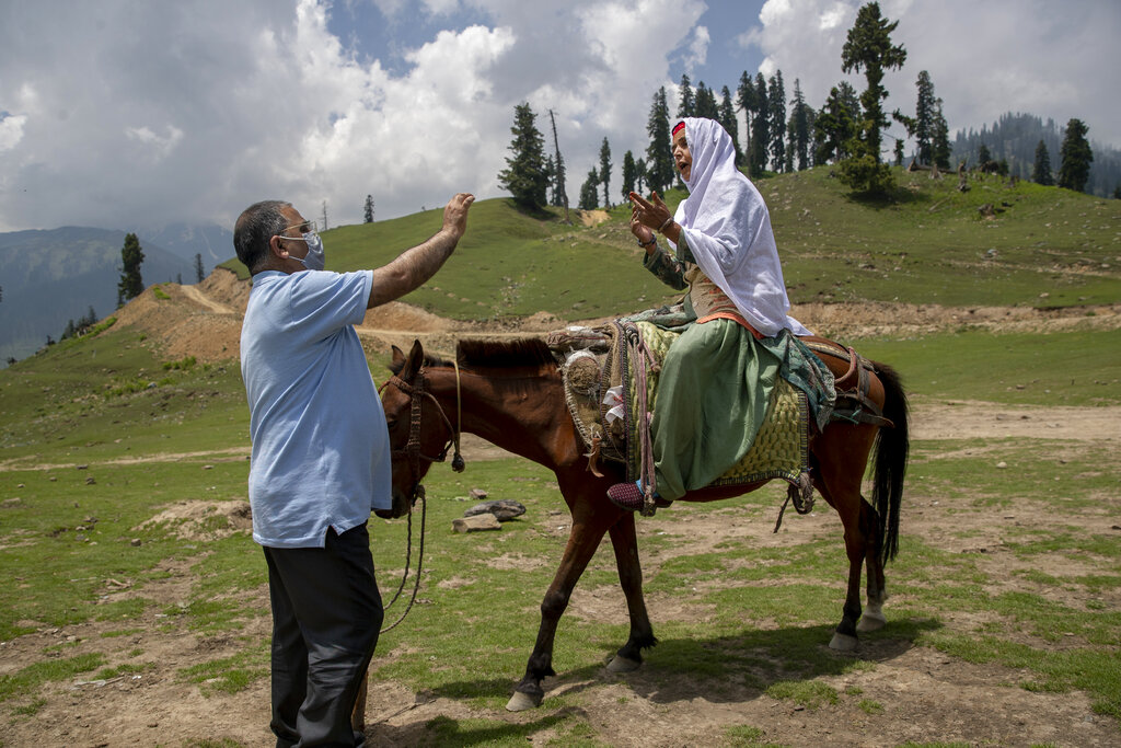 Dr. Tajamul-Hussain Khan, chief medical officer unsuccessfully tries to convince a Kashmiri nomad woman sitting on horse back who refused to let her 30 year old son to be vaccinated during a COVID-19 vaccination drive in Tosamaidan, southwest of Srinagar, Indian controlled Kashmir on June 21, 2021. (AP Photo/Dar Yasin)