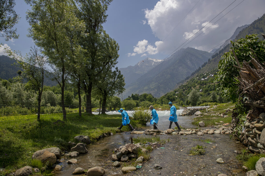 Healthcare workers Masrat Farid and her colleagues cross a stream near river Sind to reach villages on the upper reaches during a COVID-19 vaccination drive in Gagangeer, northeast of Srinagar, Indian controlled Kashmir on June 22, 2021. Farid has traveled to long distances for vaccinating mostly shepherds and nomadic herders in the remote meadows of the Himalayan region of Indian-controlled Kashmir. Her challenge has not been the treacherous terrain but to persuade women to get COVID-19 vaccines. “Everywhere we go it seems rumors reach earlier than we do, and it makes our job difficult,” Farid said recently during a vaccination campaign at a high altitude meadow. (AP Photo/Dar Yasin)