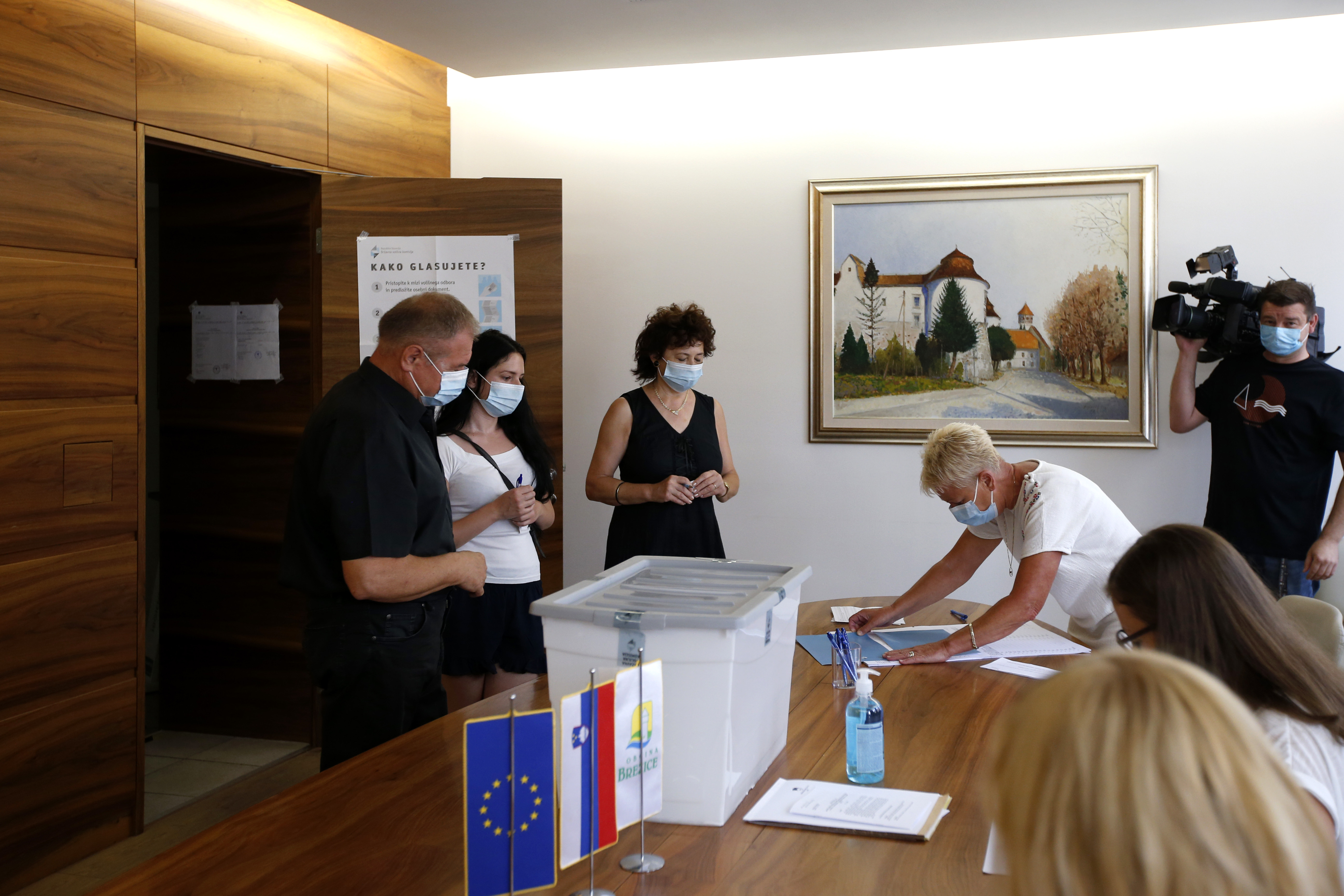 Voters register at a polling station in Brezice, Slovenia, Sunday, July 11, 2021. Slovenians voted in a referendum on changes to the country’s waters management law that is seen as a test for the government of right-wing Prime Minister Janez Jansa. Jansa’s government approved the amendments in March but ecologists have pushed through the referendum saying they threaten the environment by paving the way for construction by the sea, rivers and lakes. (AP Photo)