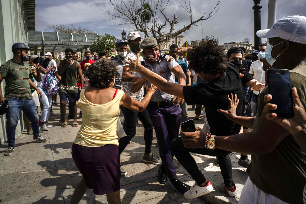Police scuffle and detain an anti-government demonstrator during a protest in Havana, Cuba, Sunday July 11, 2021. Hundreds of demonstrators went out to the streets in several cities in Cuba to protest against ongoing food shortages and high prices of foodstuffs, amid the new coronavirus crisis. (AP Photo/Ramon Espinosa)