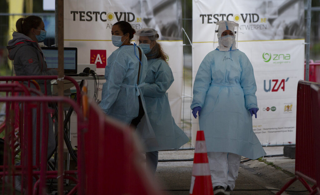 Health care workers wait to administer nose-swab tests at the mobile COVID-19 testing site in Antwerp, Belgium, Tuesday, Oct. 20, 2020. Bars and restaurants across Belgium have been shut down for a month and a night-time curfew entered into force Monday, as health authorities warned of a possible sanitary 