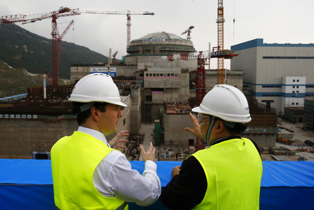FILE - In this Oct. 17, 2013, file photo, then British Chancellor of the Exchequer George Osborne, left, chats with Taishan Nuclear Power Joint Venture Co. Ltd. General Manager Guo Liming as he inspects a nuclear reactor under construction at the nuclear power plant in Taishan, southeastern China's Guangdong province. The Taishan nuclear plant near Hong Kong suffered five broken fuel rods in a reactor but no radioactivity leaked, the government said Wednesday in its first confirmation of the incident that prompted concern over the facility’s safety. (AP Photo/Bobby Yip, Pool, File)