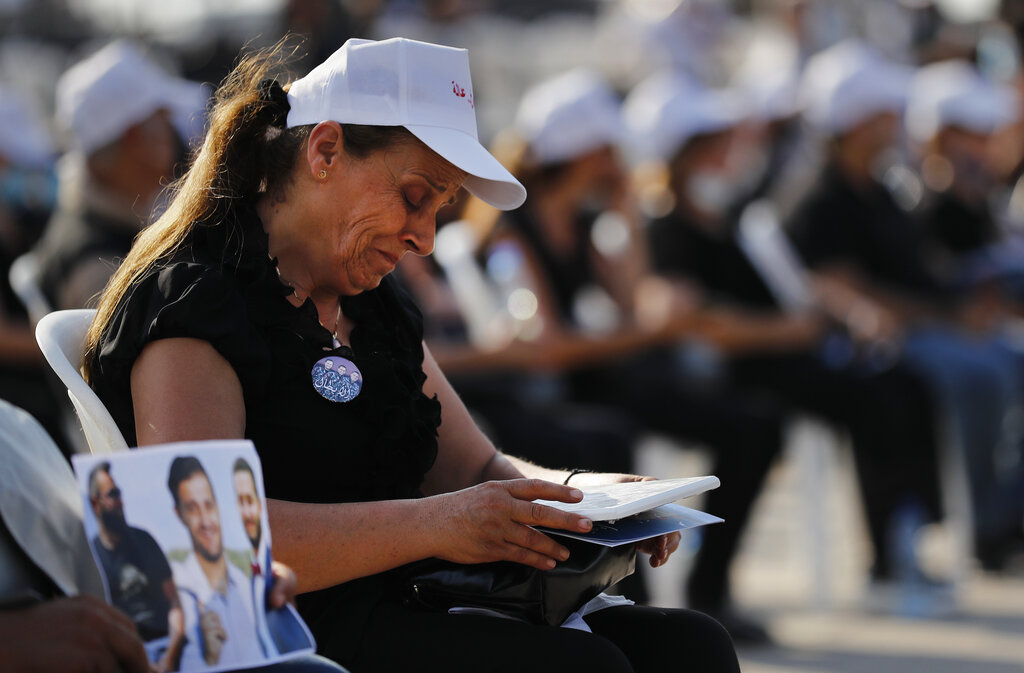 A relative of a victim who was killed in the massive blast last year at the Beirut port, weeps as she attends a mass held to commemorate the first year anniversary of the blast, at the Beirut port, Lebanon, Wednesday, Aug. 4, 2021. United in grief and anger, families of the victims and other Lebanese came out into the streets of Beirut on Wednesday to demand accountability as banks, businesses and government offices shuttered to mark one year since the horrific explosion. (AP Photo/Hussein Malla)